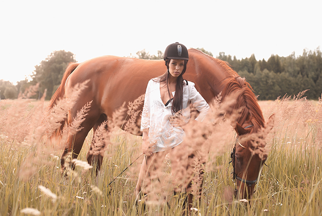 Une jeune femme et son cheval après la pratique de l'équitation.